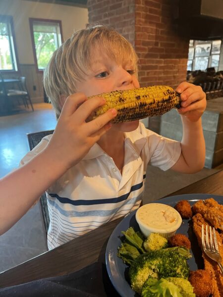 Young boy eating corn